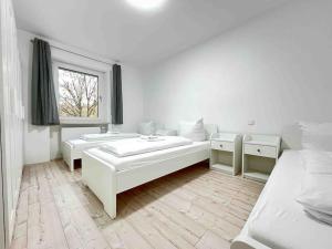a white room with two beds and a window at LAP101 - Große Moderne Monteurwohnung Übergangswohnung in Lappersdorf