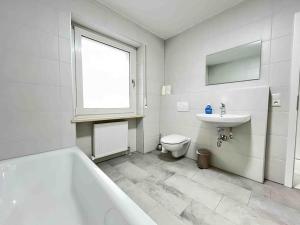 a bathroom with a tub and a toilet and a sink at LAP101 - Große Moderne Monteurwohnung Übergangswohnung in Lappersdorf