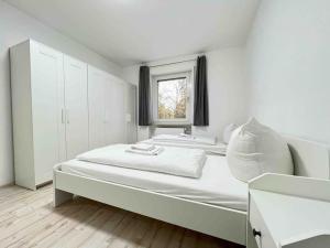 a white bedroom with a large bed and a window at LAP101 - Große Moderne Monteurwohnung Übergangswohnung in Lappersdorf +7 photos