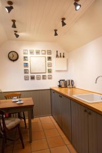 a kitchen with a counter and a table and a sink at Shepherd's Hut at High Gardens in Hereford +38 photos