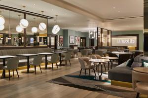 a restaurant with tables and chairs and a lobby at Strand Palace in London