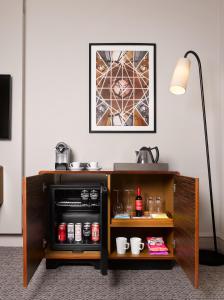 a table with a microwave in a room with a lamp at Strand Palace in London