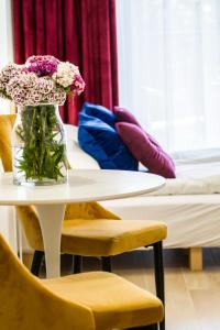 クラクフにあるPiedmont Houseの椅子とテーブルに座る花瓶