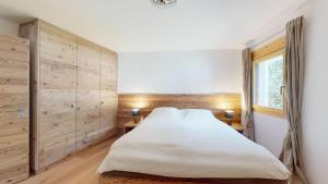 a bedroom with a large bed and wooden walls at Abitaziun Cravunera 27 - Sils Maria in Sils Maria