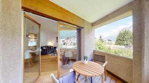 a dining room with a table and a large window at Abitaziun Cravunera 27 - Sils Maria in Sils Maria