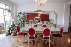 une salle à manger avec une table et des chaises rouges dans l'établissement Extravagance in heart of SP, à São Paulo