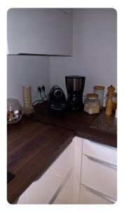 a kitchen with a counter top with a blender and other items at Chambre Vert Sauge, lit double 2 personnes, Maison en plein coeur du Parc Régional du Vexin in Hérouville