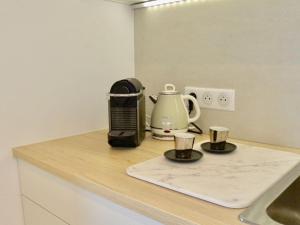 un bancone da cucina con una macchina per il caffè e un bollitore per il tè di Le doux venir a Douvaine