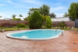 a swimming pool in a yard with a brick patio at Nanas House Swan BnB Management in Perth