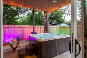 a hot tub on a patio with a fence at Two-House Private 10BR Compound - DT 6 Min Drive in Austin