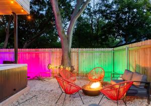 a patio with chairs and a table and a fence at Two-House Private 10BR Compound - DT 6 Min Drive in Austin