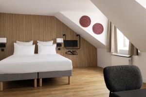 a bedroom with a bed and a chair at Korner Opera in Paris +35 photos