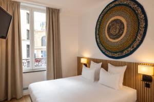 a hotel room with a bed and a window at Korner Opera in Paris