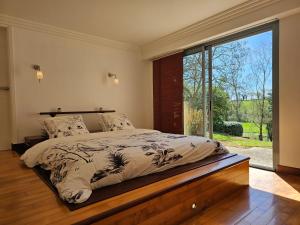 une chambre avec un lit avec une grande fenêtre dans l'établissement Magnifique Villa privative avec Piscine et Spa pour 15 personnes, à La Tessoualle