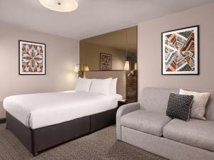 a hotel room with a bed and a couch at Strand Palace in London