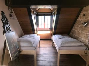 two beds in a room with a window at Ferienwohnung TURMZIMMER im Rittergut Leppersdorf bei Radeberg in Wachau
