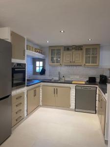 een keuken met houten kasten en een aanrechtblad bij maison Sainte Maxime VAR in Le Plan