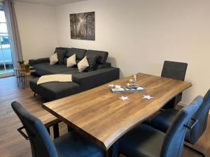 a living room with a wooden table and a couch at Ferienhaus am Riedbach in Birstein