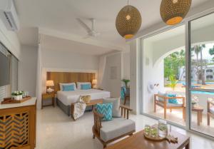 a bedroom with a bed and a living room at Diamonds Leisure Beach & Golf Resort in Diani Beach