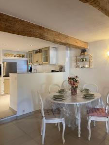 een witte eetkamer met een witte tafel en stoelen bij maison Sainte Maxime VAR in Le Plan