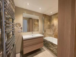 een badkamer met een wastafel en een ligbad bij maison Sainte Maxime VAR in Le Plan