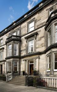 a large stone building with stairs in front of it at Grosvenor Suites in Edinburgh