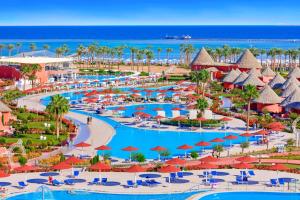 沙姆沙伊赫Pickalbatros Laguna Vista Aqua Park - 24 HRS All Inclusive的享有带游泳池和遮阳伞的度假村的空中景致