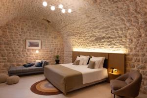 a bedroom with a king sized bed and a couch at Palace Natali in Dubrovnik