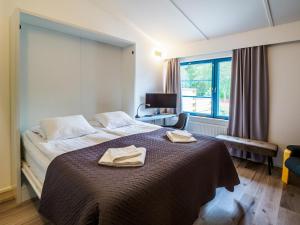a hotel room with a bed with two towels on it at Polku Hotelli in Vihti