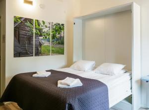 a bedroom with a bed with two towels on it at Polku Hotelli in Vihti