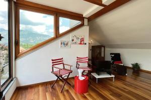 a living room with two chairs and a window at House Bluette - Affitti Brevi Italia in Malgrate