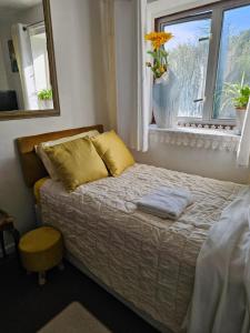 a bedroom with a bed and a window with a vase at Cuisinease in Ollerton