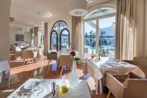 a restaurant with white tables and chairs and windows at Suite Appartement 713 in Ascona