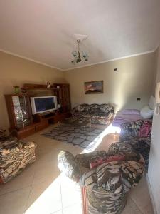 Una sala de estar con sofás y un televisor de pantalla plana. en Durres Dream Escape, en Durrës