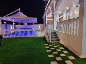 a night view of a house with a green lawn at سمارت شاليه: Smart Chalet in Salalah +14 photos