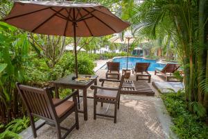 a table and chairs with an umbrella next to a pool at Railay Village Resort in Railay Beach