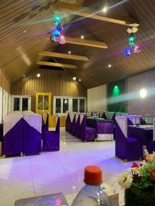 a room with purple tables and chairs and lights at Habib Green Cottage in Upper Neelun