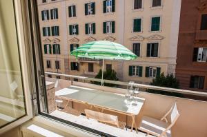 a balcony with a table and an umbrella at Magenta Collection Fornaci in Rome