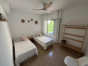 Un dormitorio con dos camas y una ventana. en Ca la Pepeta i Josep, en Deltebre