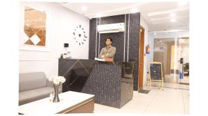 a man standing behind a counter in a room at Hotel The Emporio A Corporate suites in Ghaziabad