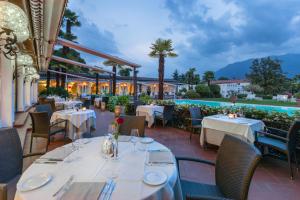 a restaurant with tables and chairs and a pool at Suite Appartement 713 in Ascona