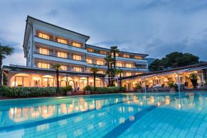 a hotel with a swimming pool in front of a building at Suite Appartement 713 in Ascona
