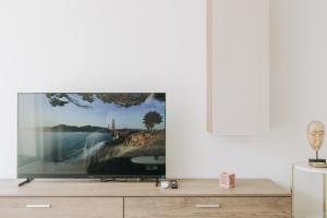 a tv sitting on a dresser in a living room at B5 The Palm Court Apartment in St Paul's Bay
