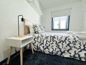 een slaapkamer met een bed en een nachtkastje naast een bed bij Guest House DML in Aveiro