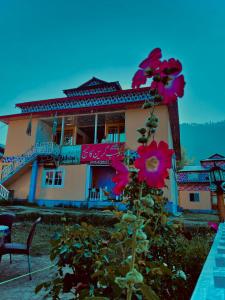 a building with pink flowers in front of it at Habib Green Cottage in Upper Neelun