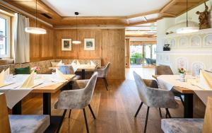 a restaurant with wooden walls and tables and chairs at Bloberger Hof in Salzburg