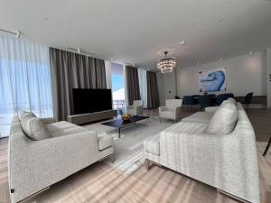 a living room with two couches and a flat screen tv at Sea Star Budva in Budva