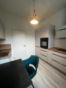 a kitchen with a table and a blue chair at Lisboa: Messe-/Business-/Ferienwohnung in Hilden +20 photos
