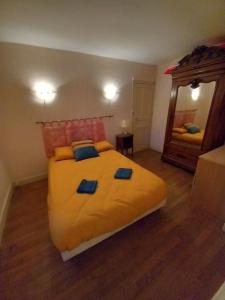 a bedroom with a large yellow bed and a mirror at Via Lactéa in Saint-Goussaud