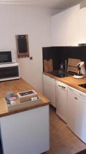 a kitchen with white cabinets and a stove top oven at Au Petit Conf'Orres in Les Orres